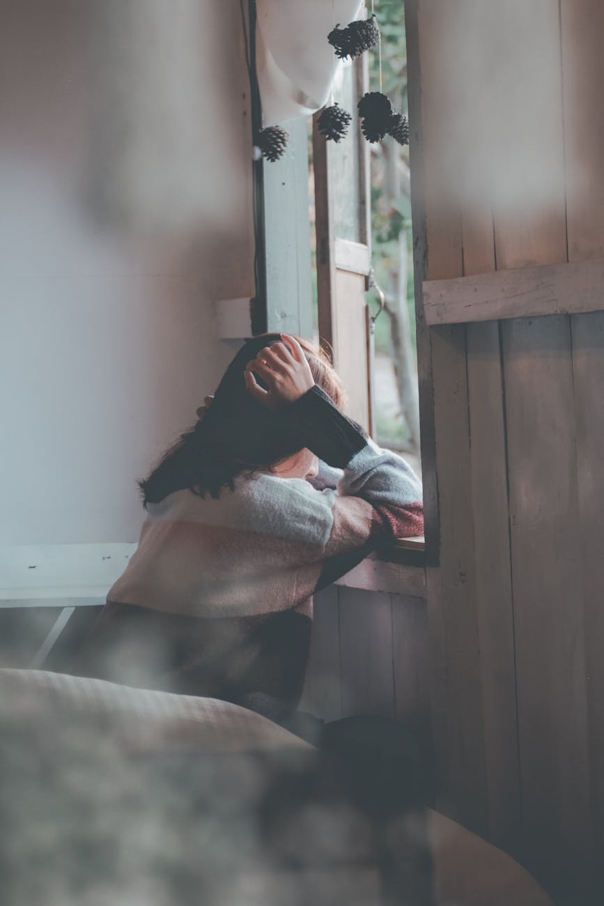 photo of a person leaning on wooden window- depression