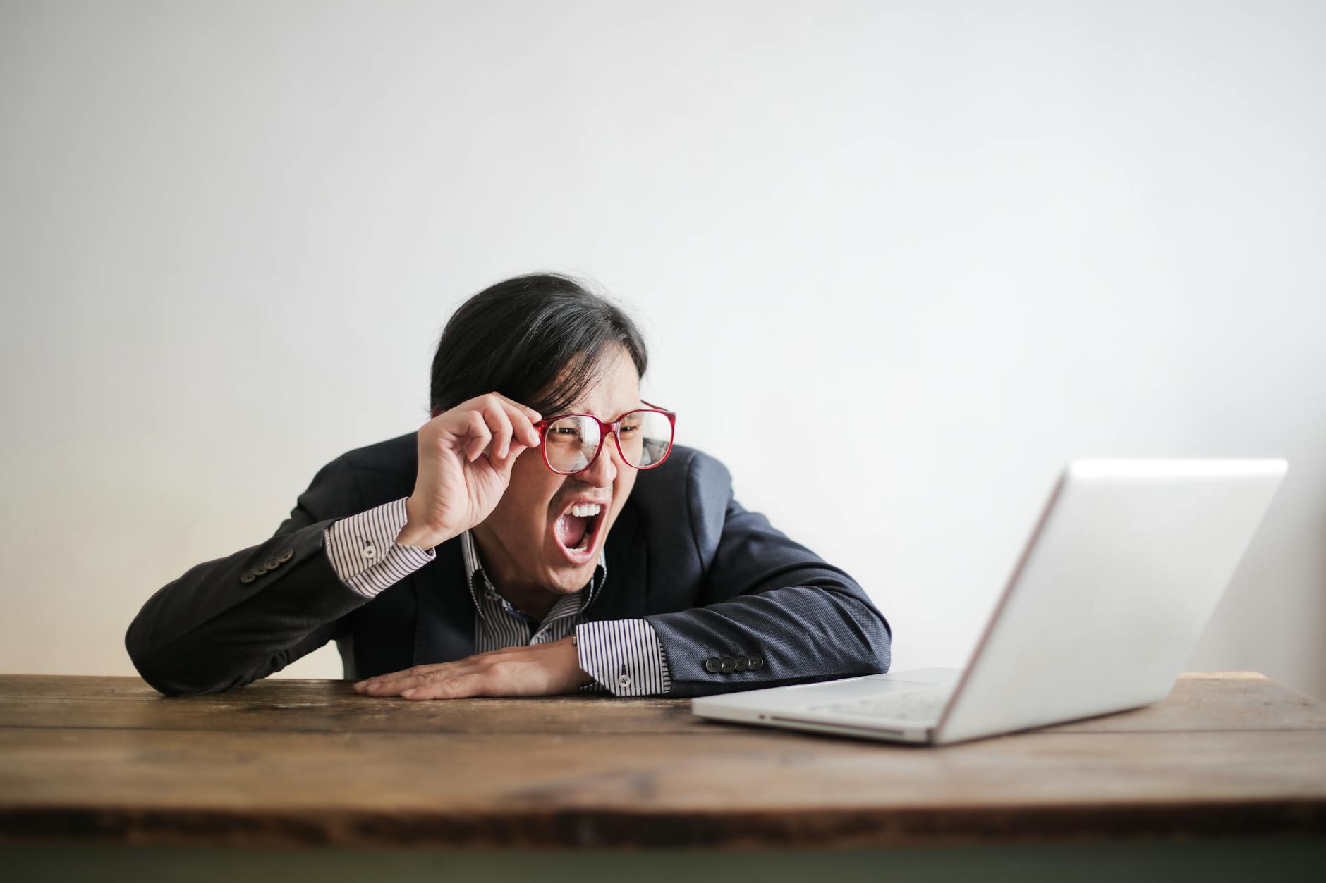 yelling formal man watching news on laptop maybe adhd