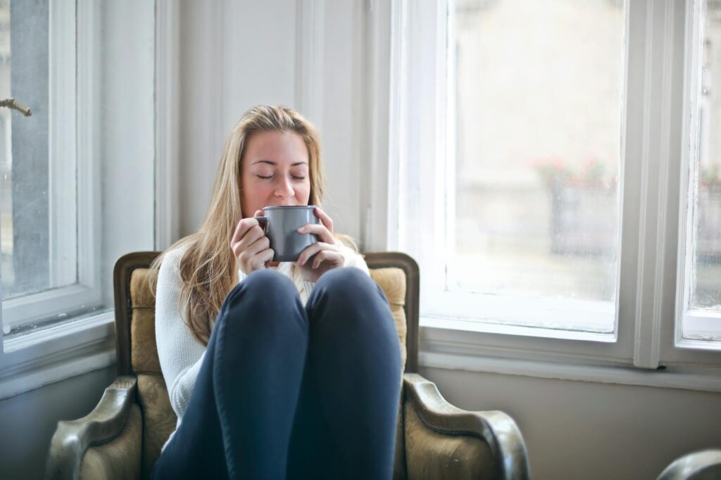 woman holding gray ceramic mug 